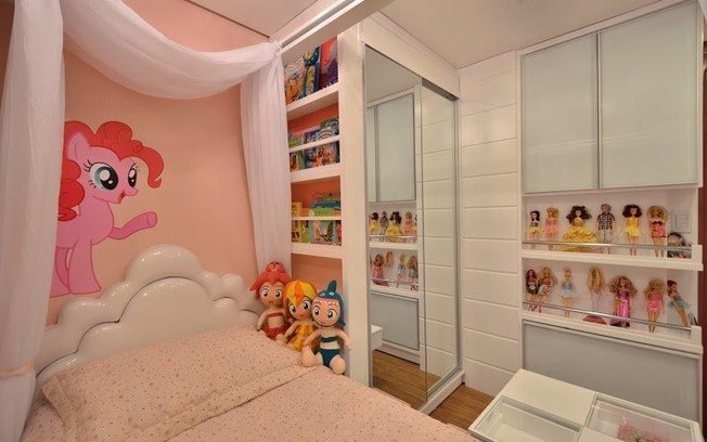 As bonecas do quarto projetado por Paula Meneghel não ficam escondidas: ao mesmo tempo em que enfeitam, já estão à mão da menina para brincar