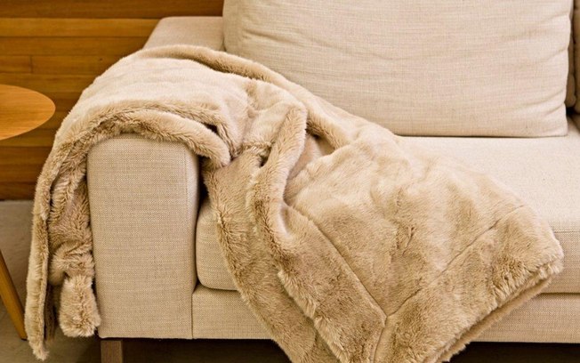 Outra possibilidade é cobrir o sofá – parcialmente ou não – com mantas e tecidos. Vale usar xales e pashminas para criar um novo ponto focal