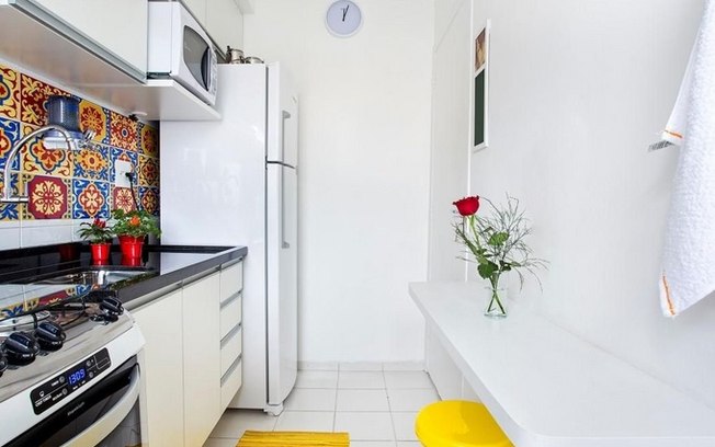 Uma boa saída para cozinhas estreitas é adicionar uma bancada à parede oposta ao móveis de serviço, como no projeto de Luciane Mota