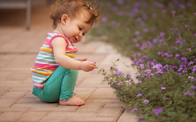Estimule os pequenos a tocar flores, folhas e árvores quando estiverem em parques ou jardins. O contato com a natureza desenvolve o respeito por ela