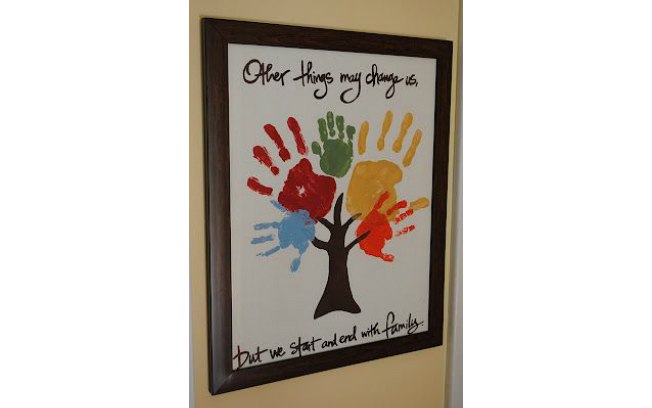 Um quadro na parede com a mão de cada membro da família é uma ideia criativa