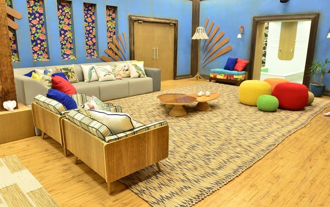Mobiliário mais orgânico, com tapete de palha, muita madeira clara e tecidos chita